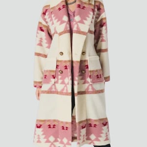 Peut inclure: Long manteau croisé avec une base crème et un motif géométrique rose et marron. Le manteau a un col cranté, deux poches avant et des boutons dorés. Le motif rappelle les textiles amérindiens. La longueur du manteau est d'environ 130 cm.