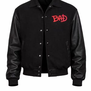 May include: Black varsity jacket with black leather sleeves and a black ribbed hem and cuffs. The jacket has a button-up front and a red embroidered "BAD" logo on the chest.