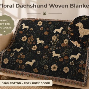 May include: A black woven blanket with a floral dachshund design, displayed on a beige sofa. The blanket features tan dachshunds and flowers. The text on the blanket says "100% Cotton Cozy Home Decor".