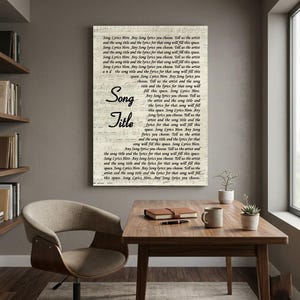 May include: A framed canvas print featuring sheet music and the words "Song Title" in a handwritten font. The background is a light beige color. The text "Song Lyrics Here" is repeated throughout the print. The print is displayed in a room with a wooden table and chair.