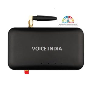 May include: A black rectangular Voice India business voice broadcasting server device featuring a single black antenna with a gold-colored connector, four small indicator lights, and a red SIM card partially inserted into the bottom edge.