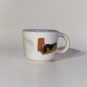 Handmade ceramic mug with abstract glaze and gold accent