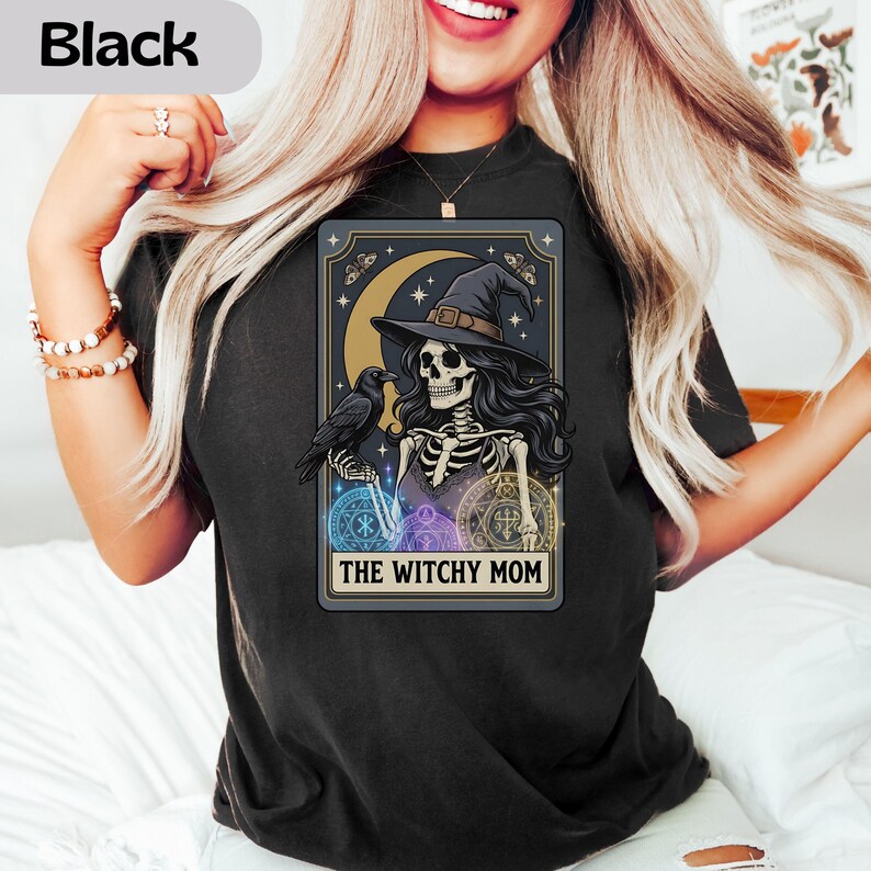 Black t-shirt with "The Witchy Mom" tarot card design featuring a skeleton, raven, moon, and stars.