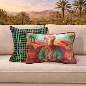 Puede incluir: Dos cojines decorativos sobre un sofá beige. Uno tiene un estampado de pata de gallo verde, negro y amarillo. El otro presenta un camello con una túnica sosteniendo una taza, con un fondo de escena desértica.