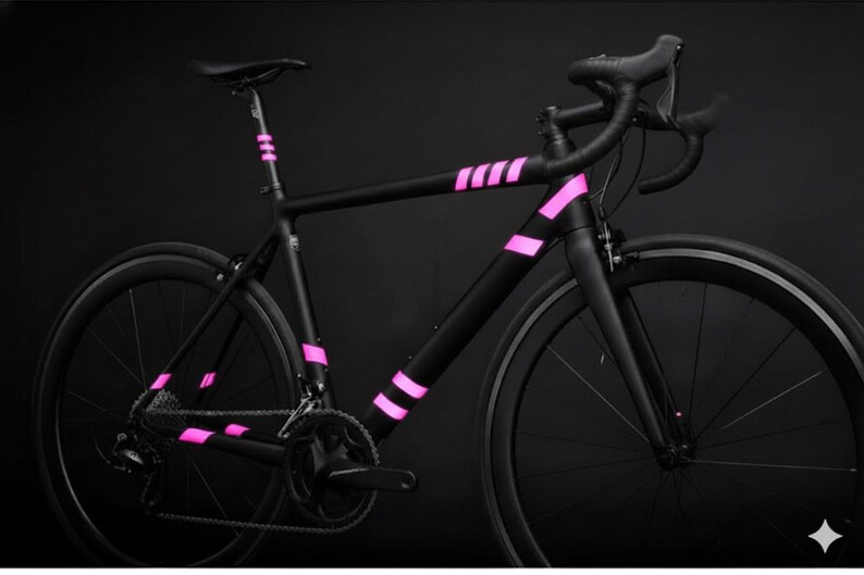 May include: A sleek black road bike with vibrant pink accents. The bicycle features a matte black frame with pink stripes on the frame and seat post. The wheels and components are black, creating a striking contrast against the pink details. A modern and stylish design.