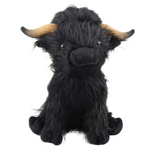 May include: A plush Highland cow toy with black fur and brown horns. The stuffed animal has a soft, shaggy texture and a friendly expression. The toy is sitting upright, with its legs and hooves visible.