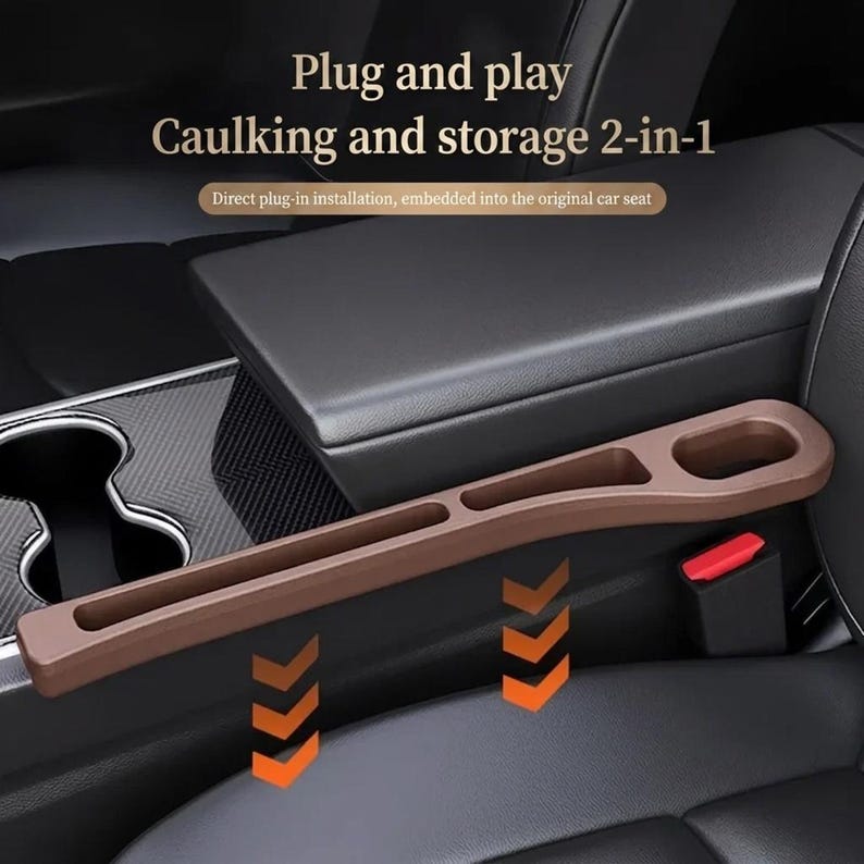 Puede incluir: Un organizador de almacenamiento marr&oacute;n para el hueco del asiento del coche con un dise&ntilde;o largo y estrecho y un portavasos. El texto dice: Plug and play, Caulking and storage 2-in-1, Direct plug-in installation, embedded into the original car seat.