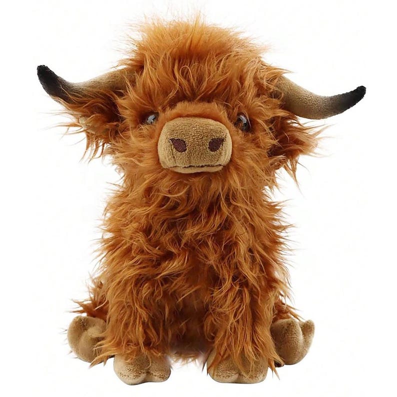 May include: A plush Highland cow toy with shaggy, reddish-brown fur. The stuffed animal has a light brown snout, small brown eyes, and curved horns with black tips. The toy is sitting upright with its legs extended.