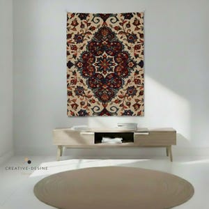 Peut inclure: Une tapisserie beige avec un motif de médaillon central avec des motifs floraux bordeaux, marine et sarcelle. La tapisserie est accrochée à un mur blanc au-dessus d'une console en bois clair. Un tapis rond beige est au sol.