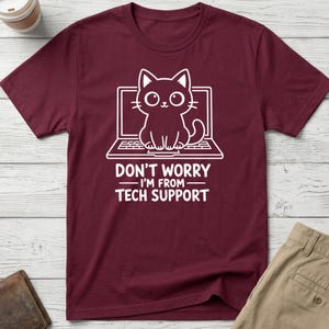 May include: Burgundy t-shirt featuring a white graphic of a cat on a laptop. The text "DON'T WORRY - I'M FROM - TECH SUPPORT" is printed below the cat and laptop design.