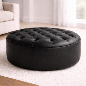 May include: A circular, black ottoman with a buttoned, tufted top. The ottoman is made of a dark, smooth material and is placed on a light-coloured rug. The design is classic and would suit a living room.