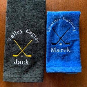 May include: Two embroidered towels, one black with the text "Valley Eagles" and the name "Jack" and the other blue with the text "Lysander Lightning" and the name "Marek".