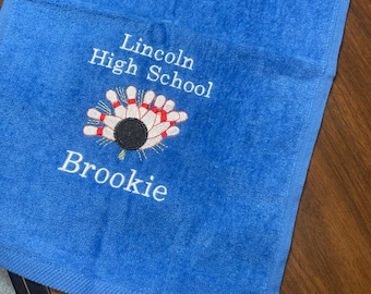 May include: Blue towel with white embroidery. The embroidery says "Lincoln High School" and features a bowling pin and ball graphic. The name "Brooke" is also embroidered on the towel.
