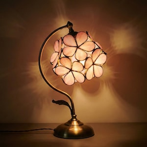 Abajur de mesa estilo Tiffany com vitral em formato de flor rosa, ideal para cabeceira ou como luz noturna.