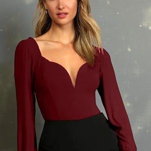 Könnte beinhalten: Ein weinrotes Langarm-Top mit tiefem V-Ausschnitt und figurbetonter Silhouette. Das Top wird mit einer schwarzen, hoch taillierten Hose kombiniert. Das Outfit eignet sich für formelle oder halbformelle Anlässe.