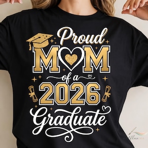 May include: Black t-shirt featuring a gold and white design. The text reads "Proud MOM of a 2026 Graduate" with a heart, graduation cap, and scroll illustrations. The lettering style combines script and block fonts.