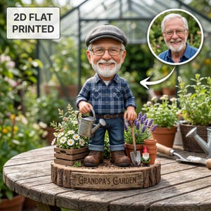 Könnte beinhalten: 2D-flach gedruckte Figur eines lächelnden Mannes in einem karierten Hemd, Jeans und einer Mütze, der eine Gießkanne hält. Die Figur steht auf einem Holzsockel mit dem Text "Grandpa's Garden".