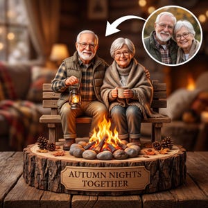Puede incluir: Una figura decorativa de una pareja de ancianos sentados en un banco de madera junto a una fogata. El hombre sostiene una linterna, la mujer una taza. Están envueltos en una manta. La base es un tronco con el texto AUTUMN NIGHTS TOGETHER.