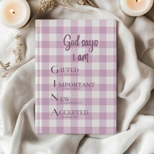 May include: A rectangular journal with a light purple and white gingham pattern. The text reads: God says i am G-I-F-T-E-D 1 Peter 4:10, I-M-P-O-R-T-A-N-T Psalm 139:14, N-E-W 2 Corinthians 5:17, A-C-C-E-P-T-E-D Romans 15:7. The name GINA is highlighted.