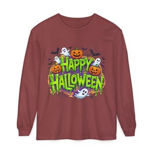 Puede incluir: Una camiseta de manga larga color granate con un estampado gráfico que muestra el texto Happy Halloween en letras de color verde lima que gotean. El diseño incluye calabazas naranjas, fantasmas blancos, murciélagos y telarañas.