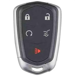 May include: A silver and black car key fob with five buttons. The buttons include lock, unlock, a circular arrow, a car trunk icon, and a red alarm icon. The key fob has a rounded, ergonomic design.