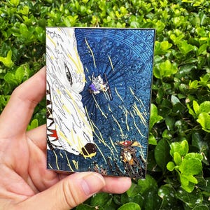 May include: A rectangular enamel pin featuring a fantasy scene. A large white wolf head is on the left, with a blue background depicting a stained-glass window design. Two figures are in the center, with yellow and orange accents.