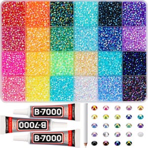 May include: A clear plastic organizer filled with colorful rhinestones in various shades, including red, orange, green, and blue. Also included are three tubes of B-7000 glue, a pencil, and a selection of rhinestones in different shapes and colors.