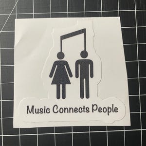 May include: A black and white sticker with a stylized image of a musical note connecting two stick figures, one female and one male. The text "Music Connects People" is below the figures.