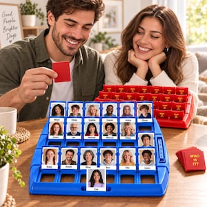 Pode incluir: Um jogo de tabuleiro de plástico azul com uma grade de cartas dobráveis com retratos e nomes de várias pessoas. O jogo inclui uma pilha de cartas vermelhas com a etiqueta "WHO IS IT?" e uma moldura de jogo de plástico vermelha ao fundo.