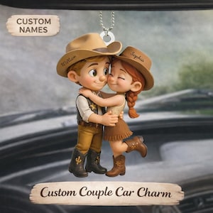 Könnte beinhalten: Ein individueller Autoanhänger mit einem Cartoon-Paar in Cowboy-Kleidung, das sich umarmt. Der Anhänger trägt die Aufschrift "Custom Names" und "Custom Couple Car Charm". Der Cowboy trägt einen Hut mit "William" und der Hut des Cowgirls trägt "Sophia".