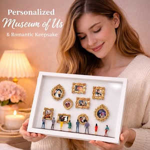 Könnte beinhalten: Eine weiße Schattenbox mit Miniatur-Fotorahmen und Figuren. Die Rahmen sind goldfarben mit aufwendigen Designs. Der Text oben lautet "Personalized Museum of Us & Romantic Keepsake."