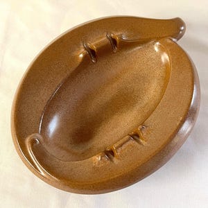 Pode incluir: Um conjunto de três canecas de cerâmica com acabamento fosco e salpicado. As canecas são em tons de creme, cinza claro e cinza escuro. Cada caneca tem um design simples e minimalista, ideal para café ou chá.