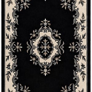 May include: A rectangular area rug featuring a deep black center and a cream-colored border. The design includes intricate floral and scrollwork patterns in shades of charcoal gray, slate, and soft beige, centered around a symmetrical medallion.