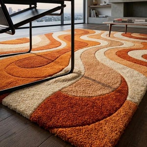 May include: A retro-style area rug with a wavy pattern in shades of orange, beige, and cream. The rug has a thick, textured pile and is placed on a dark wood floor. A black chair is partially visible in the foreground.