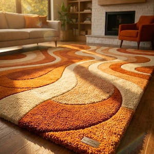 May include: A shag rug with a retro design. The rug features a wavy pattern in shades of orange, cream, and beige. The rug is rectangular and appears to be made of a soft, plush material. The rug is placed on a hardwood floor.