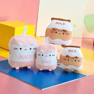 Op de afbeelding: Een set van drie keramische mokken met een gespikkelde, crèmekleurige glazuur. Elke mok heeft een handgeschilderd bloemmotief in blauw, groen en geel. De mokken hebben een eenvoudige, afgeronde vorm en een comfortabel handvat.