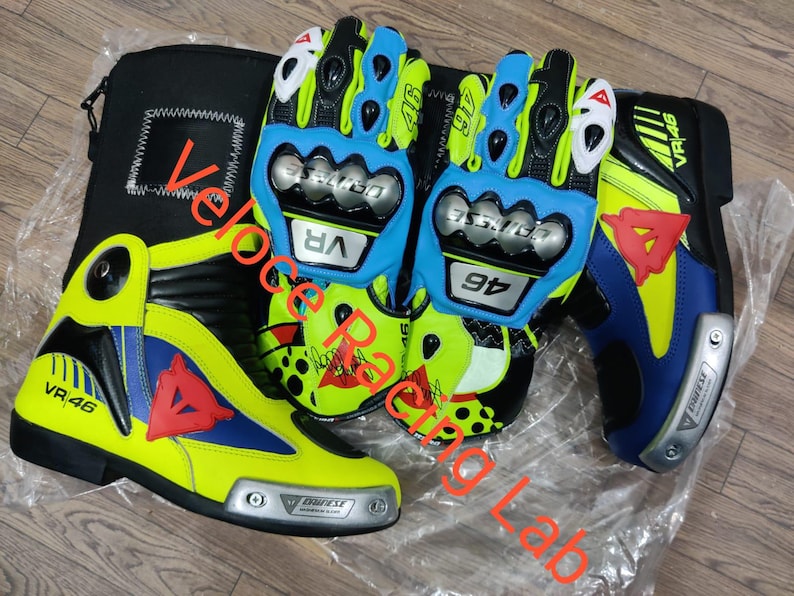 May include: A set of motorcycle gear, including a pair of blue and yellow gloves, a matching boot, and a black carrying case. The gloves and boot feature the number "46" and the "VR" logo. The boot has a red triangle design.