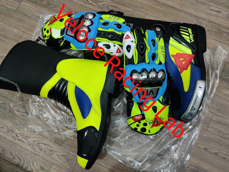 May include: Motorcycle racing gear set including a neon yellow and black boot, and blue, black, and yellow gloves. The gloves and boot have a sporty design with the text "VR46" and "Dainese".