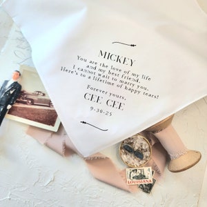 Może przedstawiać: Biała chusteczka z czarnym tekstem, kt&oacute;ry brzmi: "MICKEY You are the love of my life and my best friend. I cannot wait to marry you. Here's to a lifetime of happy tears! Forever yours, CEE CEE 9-30-25"