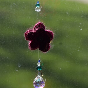 Handmade crystal suncatcher with hand-crocheted magenta flower