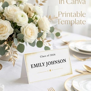 May include: A table setting with a floral arrangement of white roses and gold accents. A place card with the name "EMILY JOHNSON" is displayed. Text on the image reads "Editable in Canva", "Printable Template", and "Instant Download".