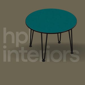 May include: A round side table with a teal top and a thin black metal frame featuring three hairpin legs. The text hp interiors is visible in the background. The table has a smooth, flat surface and a simple, functional design for home use.