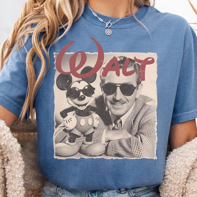 Puede incluir: Camiseta azul con un gr&aacute;fico retro de Mickey Mouse con gafas de sol junto a Walt Disney, con la palabra "Walt" en escritura roja. El dise&ntilde;o est&aacute; impreso en una camiseta azul.