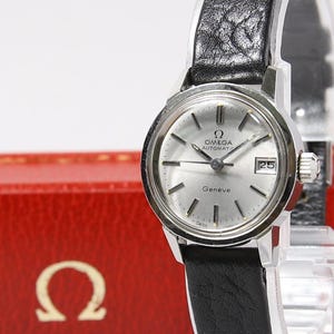 May include: A set of three ceramic mugs with a speckled, matte finish. The mugs are in shades of cream, light gray, and dark gray. Each mug has a simple, modern design and a rounded handle.