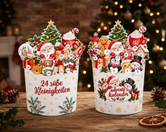 May include: Two white cylindrical advent calendars featuring colorful Christmas illustrations of Santa, snowmen, reindeer, and gifts. The left container displays the text 24 süße Kleinigkeiten, while the right container features the text advents kalender.