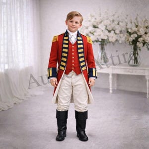 May include: A young person in a red military-style jacket with gold trim, navy blue accents, and gold epaulets. The outfit includes a red vest, white shirt, cream-colored pants, and black boots. The ensemble is reminiscent of historical military attire.