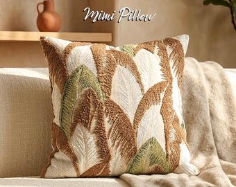 Funda de almohada bohemia con mechones: diseño de hojas de palmera tropical, cojín decorativo texturizado en tono neutro.