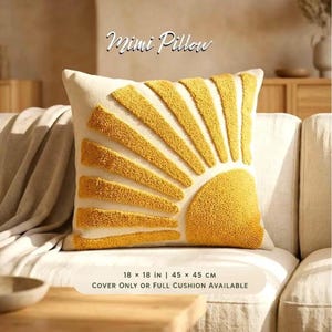May include: A square Mimi Pillow featuring a textured yellow tufted sunburst design on an off-white background. The pillow measures 18 x 18 inches. The text on the image reads Mimi Pillow and 18 x 18 in | 45 x 45 cm Cover only or full cushion available.