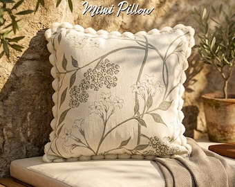Funda de cojín con estampado floral botánico y ribete de pompones: decoración rústica de estilo granja.