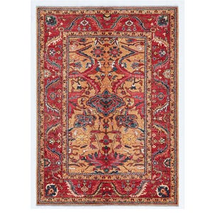 May include: A rectangular, ornate rug with a central medallion design. The rug features a rich color palette of red, gold, and blue, with intricate floral and geometric patterns. The border is a deep red, framing the central design.